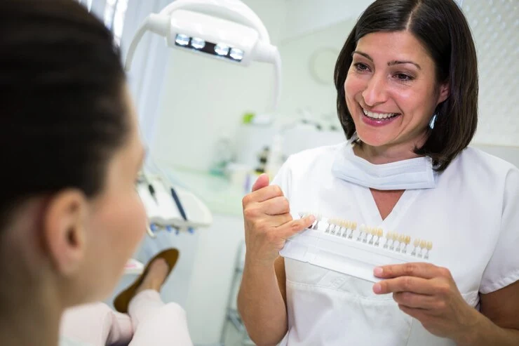 Tannlege undersøker kvinnelig pasient med blanke tenner